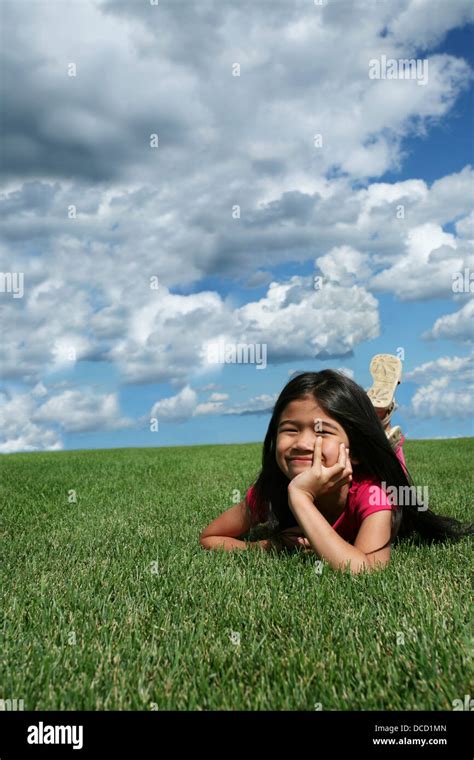 Little girl lying on grass Stock Photo - Alamy