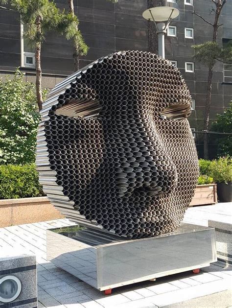 Figurative Faces Emerge From Layers of Tightly Stacked Pipes