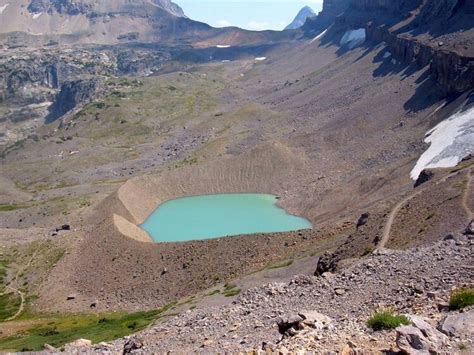 turquoise-colored tarn or glacial lake in the Grand Tetons of Wyoming that's impounded by a ...