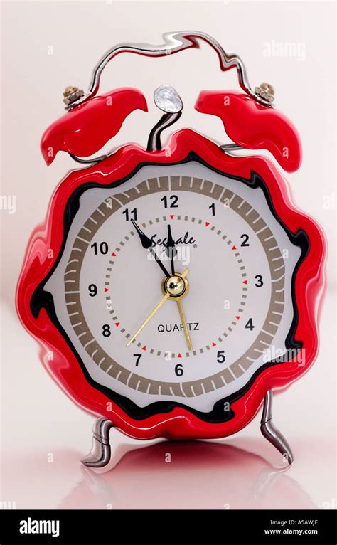 Funny alarm clock showing five to twelve Stock Photo - Alamy