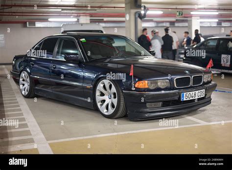 German car BMW E38 in dark color with the German imperial eagle flag on the front wings. It is a ...