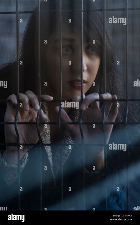 Sad woman behind bars Stock Photo - Alamy