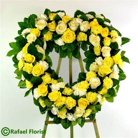 Yellow and white Heart shape memorial service flowers with roses and carnations