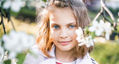 Little Girl is Walking in Spring Garder with Apple Trees and White ...