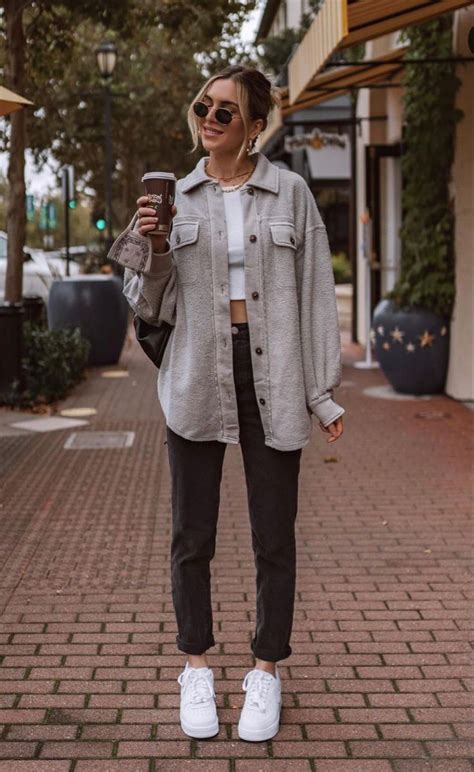 Trendy light gray shacket over white crop top and dark gray denim jeans.