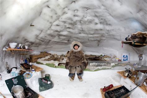 An Inuit child is sitting in an igloo on the arctic, Gjohaven, Canada ...