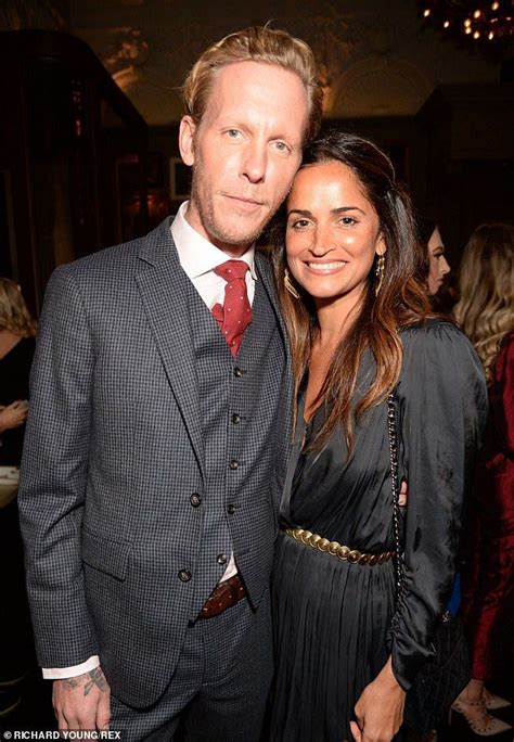 a man in a suit and tie standing next to a woman wearing a black dress