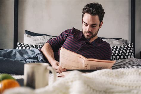 «Man Reading The Paper In Bed» del colaborador de Stocksy «Lumina» - Stocksy