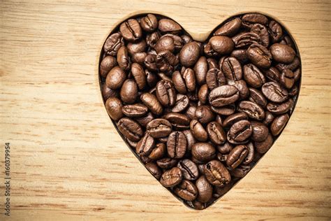 Heart shaped coffee beans on wooden board Stock Photo | Adobe Stock