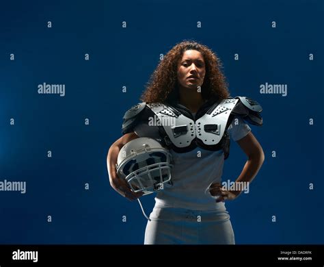 Portrait of female american football player with shoulder pads and ...