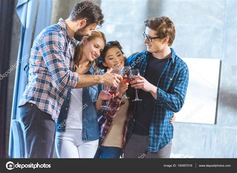 Young friends drinking wine — Stock Photo © ArturVerkhovetskiy #150957016