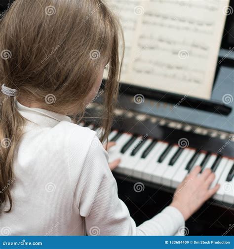 Little girl play the piano stock image. Image of female - 133684409