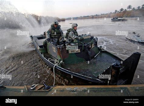 US Army soldiers use a boat to pull a section of floating assault Stock ...