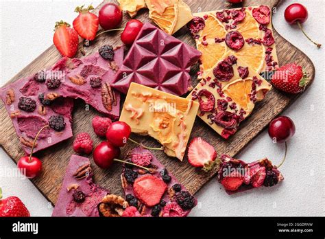 Handmade chocolate bars with fruits, berries and nuts on light ...