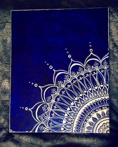 a blue and white painting on top of a black sheet with water drops in it