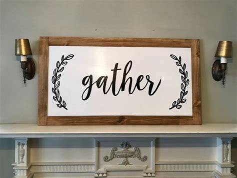 a wooden sign that says gather above a mantle