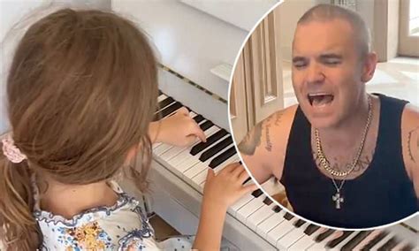 Robbie Williams sings a song written by daughter Teddy, 7, while she ...