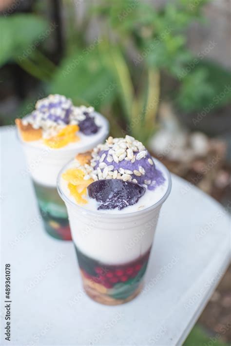 Two plastic cups of Halo-halo, a popular cold dessert in the Philippines, at an outdoor or al ...