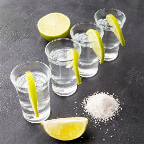 Premium Photo | High angle silver tequila shots with lime slices and salt