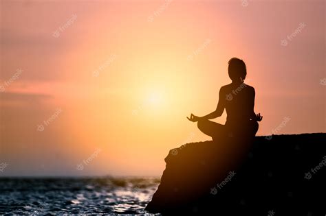 Premium Photo | Yoga silhouette young woman on the beach at sunset.