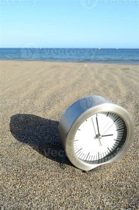 Clock on the beach sand 16734946 Stock Photo at Vecteezy