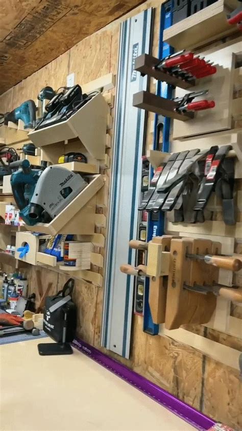 a workbench with tools hanging on the wall and some shelves full of tools