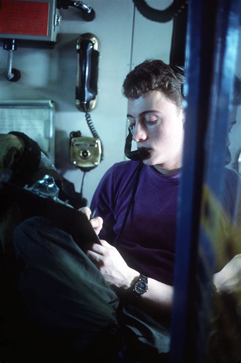 A crewman records information during flight operations on the aircraft ...