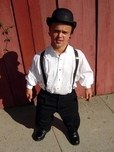 an older man in a white shirt and black suspenders is standing on the ...