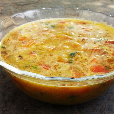 a casserole dish is sitting on a table with a glass bowl in it