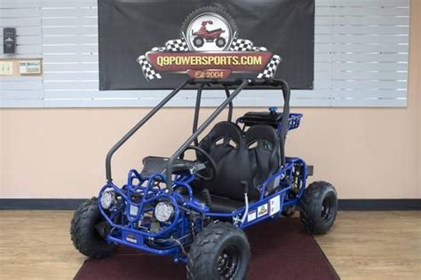 a blue four passenger buggy parked in front of a sign