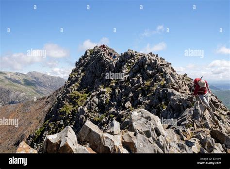 View back along Crib Goch ridge scramble with hikers scrambling at start of Snowdon Horseshoe in ...