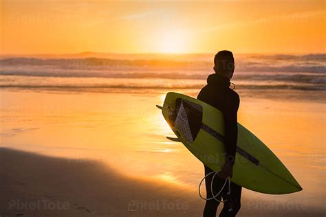 Male Surfer with a Surfboard Stock Photo - PixelTote