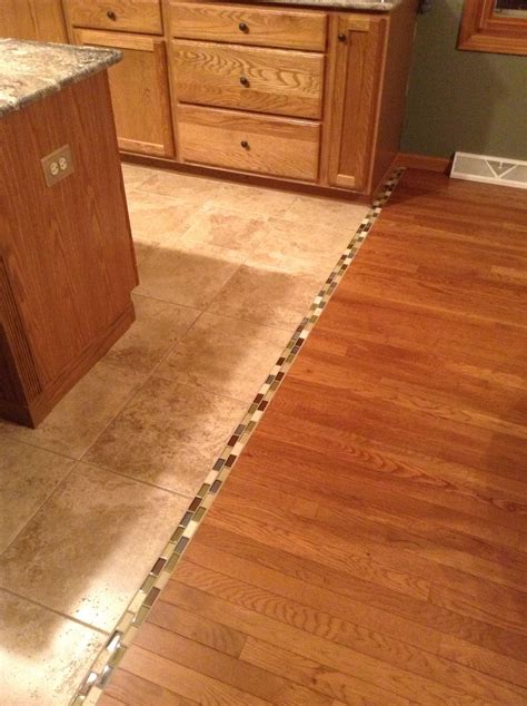 Transition between hardwood and tile floor... We should do this. Sooooo much prettier than the ...