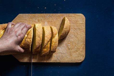 Top view to a woman's hand cutting bread on dark blue background - Creative Commons Bilder