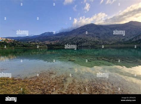 View of beautiful Kournas lake with clear turquoise water during sunset. Reflection of sun in ...