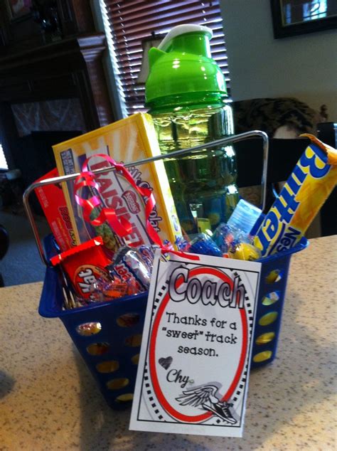 a blue basket filled with candy and snacks on top of a counter next to a green cup