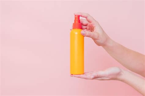 Premium Photo | Hand holding plastic spray bottle as mineral spray or hair spray on pink ...