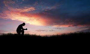 Man kneeling down in a field to pray Royalty-Free Stock Image - Storyblocks