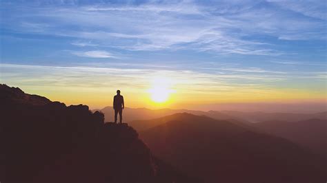 The Man Standing On The Mountain On The Picturesque Sunrise Background Stock Photo - Download ...