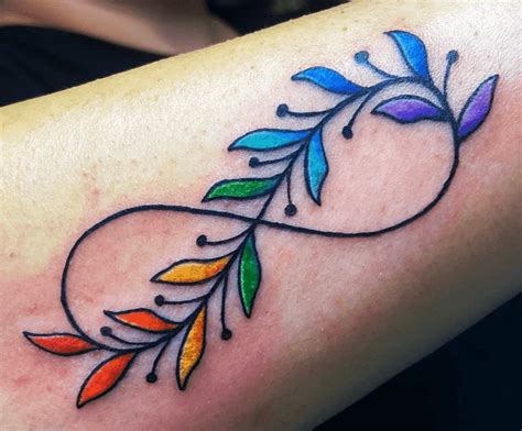 a colorful tattoo on the arm of a woman with an arrow and leaves in it