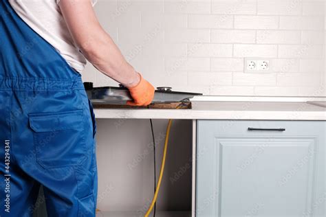 Serviceman installs new gas hob in kitchen countertop Stock Photo ...