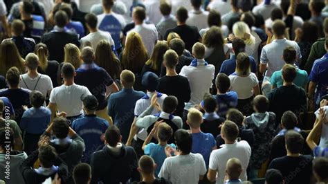 Crowd of sports fans clapping hands, soccer football admirers cheering. Stadium visitors ...