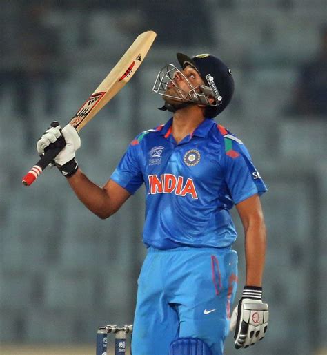 Rohit Sharma raises his bat after reaching a half-century ...