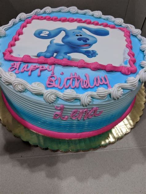 a blue birthday cake with pink and white frosting