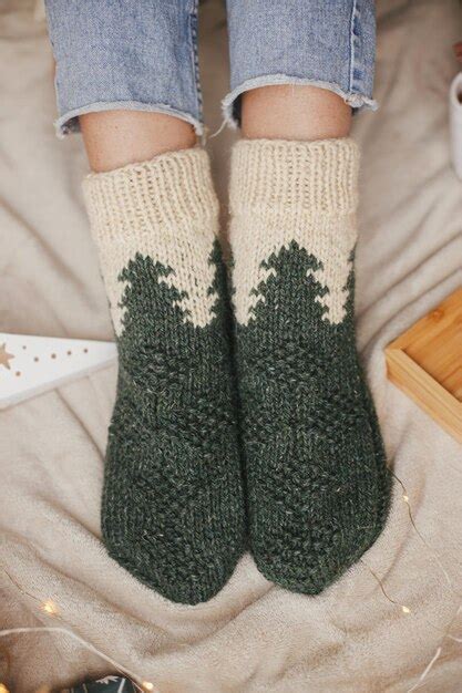 Premium Photo | Woman feet in woolen socks on soft bed with warm cup of tea christmas stars ...