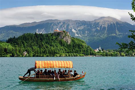 Traditional Pletna boat with colorful canopy on Lake Bled with B Photograph by Reimar Gaertner ...