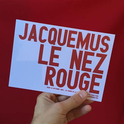 a person holding up a sticker that says jacquemus le nez rouge