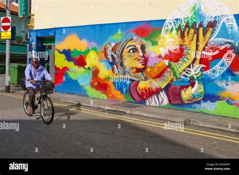 A cyclist passing a wall painting depicting a classical Indian dancer ...