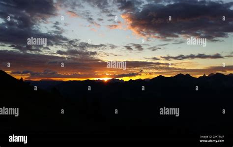 Rocky mountain silhouettes under a cloudy sky during the sunset in the evening Stock Photo - Alamy