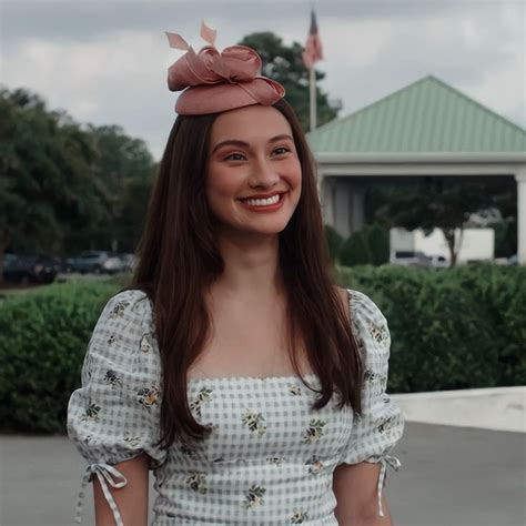 a woman with long hair wearing a dress and hat smiling at the camera ...